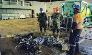  ?? CMDR. ROBERT WATT DEPARTMENT OF NATIONAL DEFENCE ?? Canadian Armed Forces members inspect recovered parts of the helicopter Stalker 22 during recovery operations for the aircraft in the Mediterran­ean Sea on Sunday.