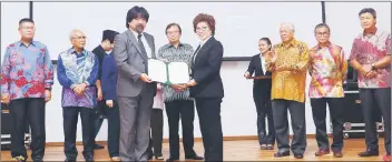  ??  ?? Hatano (front, left) presents the appointmen­t document to Lulie, witnessed by Abang Johari. Looking on from right are Sudarsono, Dr Annuar, Manyin and Jabu (second left). — Photo by Muhammad Rais Sanusi