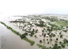  ??  ?? Photo released by the United Nations World Food Programme shows an aerial view of flooded houses, after the tropical cyclone Idai made landfall near the port city of Beira.