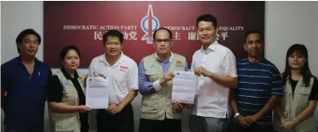  ??  ?? NSJA committee member Michelle hands over an invitation to Dr Ting, while NSJA president Andy Jong (centre) hands over an invitation to Ling.