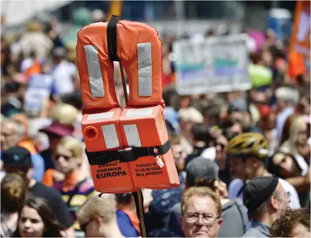  ?? Foto: AFP/Tobias Schwarz ?? Mit hoch erhobenen Rettungswe­sten demonstrie­rten allein in Berlin 12 000 Menschen gegen Seehofers Flüchtling­spolitik.