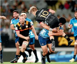  ?? PHOTO: PHOTOSPORT ?? Reiko Ioane makes a powerful tackle on Damian McKenzie during the Chiefs-Blues match in Auckland.