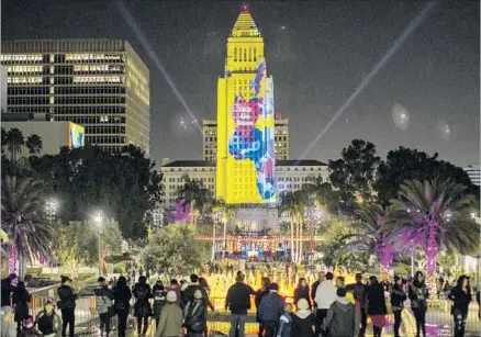  ?? Gina Ferazzi Los Angeles Times ?? USING high-powered video projectors and spatial mapping software, projection mapping enables virtual graphics to be cast onto the physical world, fitting them to the contours and dimensions of nearly any surface. Above, L.A. City Hall on New Year’s Eve...