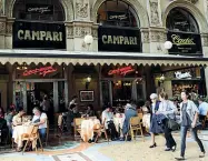  ??  ?? Le insegne Dall’alto: il ristorante «Il Salotto», il déhors della «Locanda del Gatto Rosso» e i clienti ai tavolini del Camparino in Galleria Vittorio Emanuele II