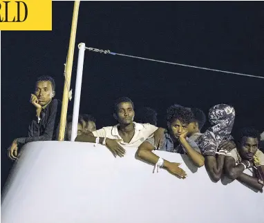  ?? FRANCESCO RUTA/ANSA VIA THE ASSOCIATED PRESS ?? Migrants wait to disembark from the Protector at Pozzallo, Sicily, early Monday after a half-dozen European countries promised to take some of them in rather than have Italy process their asylum claims alone.