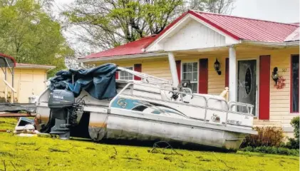  ?? THE ASSOCIATED PRESS ?? A pontoon boat sits in the front yard of a home in Screamer, Ala., after a suspected tornado touched down Wednesday.