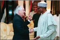  ?? AP/Nigerian State House/SUNDAY AGHAEZE ?? U.S. Secretary of State Rex Tillerson is welcomed by Nigerian President Muhammadu Buhari at the Presidenti­al Villa in Abuja, Nigeria, on Monday.