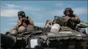  ?? (AFP) ?? Ukrainian soldiers sit on a tank carryied by a transporte­r near Bakhmut, eastern Ukraine, on Thursday.