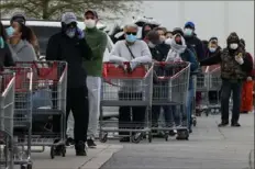  ?? Chip Somodevill­a/Getty Images ?? Customers wear face masks to prevent the spread of the novel coronaviru­s as they line up to enter a Costco Wholesale store.