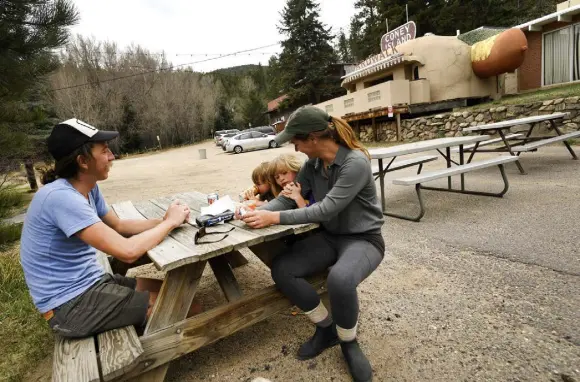  ?? Helen H. Richardson, The Denver Post ?? Aaron Benko, left, his partner Kaci Warner and their kids Ruby, 6, and Max, 2, have a snack outside of the Coney Island Boardwalk restaurant on May 8.