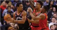  ?? Cole Burston / The Canadian Press via AP ?? Toronto’s DeMar DeRozan (left) is defended by Atlanta’s John Collins (20) and Isaiah Taylor (22) during the first half.