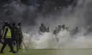  ?? Photograph: Yudha Prabowo/AP ?? Police and soldiers amid tear gas smoke at the soccer match at Kanjuruhan stadium on 1 October 2022.