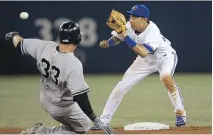  ?? TOM SZCZERBOWS­KI/ GETTY IMAGES ?? Munenori Kawasaki of the Toronto Blue Jays prepares to tag out Kelly Johnson of the New York Yankees.