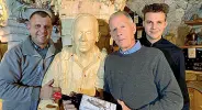  ??  ?? Un Gonzalier
La statua in legno cinta da Carmelo (a sinistra), Bruno e Federico Grigoletti.