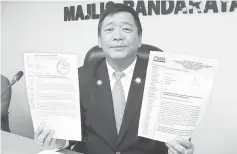  ??  ?? Lai showing the letters submitted by PBMS Miri and DUBS Miri on their members who are interested to apply for the temporaril­y trading licences at North Yu Seng Road.