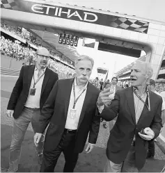  ?? — Reuters ?? Chase Carey, chief executive and chairman of Formula One (centre) arrives at starting grid of Abu Dhabi Grand Prix.