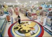  ?? DANIEL HULSHIZER — THE ASSOCIATED PRESS FILE ?? A woman pushes a shopping cart over a graphic of Toys R Us mascot Geoffrey the giraffe at the Toys R Us store in Raritan, N.J.