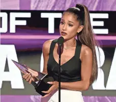  ?? KEVIN WINTER, GETTY IMAGES ?? Ariana Grande accepts the American Music Awards’ biggest honor, artist of the year, Sunday night in Los Angeles.