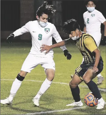  ??  ?? YUMA CATHOLIC’S HECTOR OLMOS (right) controls the ball in front of Avondale-St. John Paul II Catholic’s Eric Romero during the first half of Thursday night’s game at Ricky Gwynn Stadium.