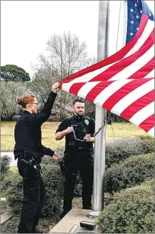  ?? Westside Eagle Observer/RANDY MOLL ?? Gentry school resource officer Barbara Duffney and Gentry patrol officer Chase Robison, both veterans of the U.S. Marine Corps, raise the flag in special Veterans Day ceremonies at the Gentry Police Station at 11 a.m. on Friday, Nov. 11.