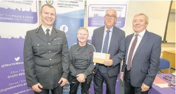  ?? Picture: MIKE DEAN (Eye Imagery) ?? Assistant Chief Constable Richard Debicki, North Wales Police and Crime Commission­er Arfon Jones and PACT chairman David Williams hand the £2,500 funding grant over to Maesgeirch­en Amateur Boxing Club trainer Brian Williams