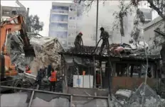  ?? SANA via Associated Press ?? Emergency service workers clear the rubble at a destroyed building struck by Israeli jets Monday in Damascus, Syria. The airstrike destroyed the consular section of Iran's embassy in Syria, killing a senior Iranian military adviser and roughly a handful of other people.