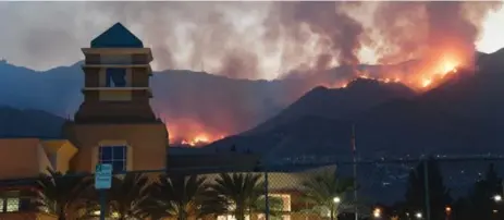  ?? ROBYN BECK/AFP/GETTY IMAGES ?? Flames engulfing nearly 20 sq.-km of brush-covered California mountains led to evacuation orders for Los Angeles, Burbank (above) and Glendale.