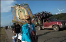  ?? REBECCA BLACKWELL — THE ASSOCIATED PRESS ?? Erlin Troches, a 43-year-old Honduran migrant from the city of Santa Barbara, carries an image of the Virgin of Guadalupe that was given to him by a priest in southern Mexico.