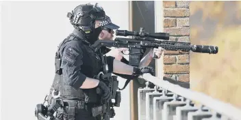  ??  ?? Armed police at the scene in Crawley on Monday afternoon