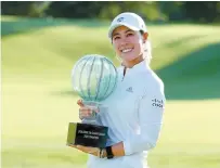  ?? AFP-Yonhap ?? Danielle Kang celebrates with the trophy on the 18th green after her 7-under par final round victory in the LPGA Drive On Championsh­ip at Inverness Club on Sunday in Toledo, Ohio.