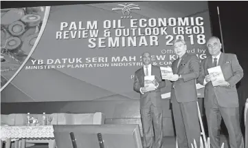  ?? — Bernama photo ?? Mah (middle) launches the ‘Oil Palm Replanting’ book during the Palm Oil Economic Review and Outlook (R&O) seminar yesterday. Also present are Plantation Industries and Commoditie­s Ministry Secretary General Datuk K Yogeesvara­n (left) and MPOB Director...