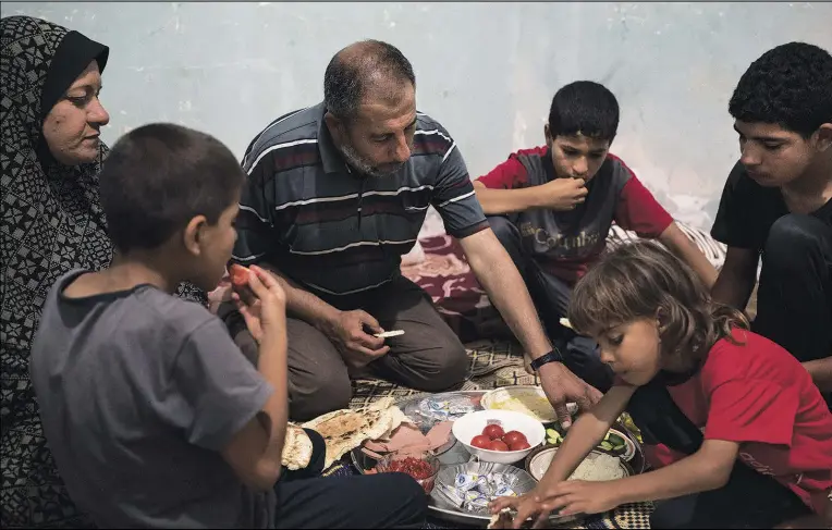  ?? (AP/Felipe Dana) ?? Zaki and Jawaher Nassir have dinner with their sons June 21 in an apartment they rented after their house was heavily damaged by airstrikes in Beit Hanoun, northern Gaza Strip.