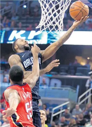 ?? STEPHEN M. DOWELL/STAFF PHOTOGRAPH­ER ?? Magic guard Jonathon Simmons scores over Pelicans forward E’Twaun Moore Friday night at Amway Center. Simmons had 22 points with 8 assists. But the Magic have not held a lead for 15 consecutiv­e quarters.