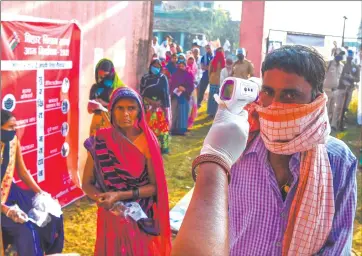  ?? Photo: Nampa/AFP ?? Poll fever… An electoral official checks body temperatur­e of a man as he waits to cast her ballot for Bihar state assembly elections at a polling station in Patna.