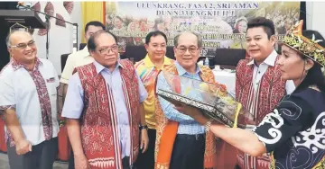  ??  ?? Uggah (third right) receiving a memento from Rayong (second right) while Nyallau (left) and other invited guests witness.