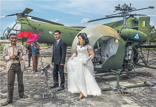  ?? MINZAYAR OO PHOTOS THE NEW YORK TIMES ?? A couple pose for a pre-wedding photo shoot at the sprawling Defence Services Museum's compound in Naypyitaw, Burma.