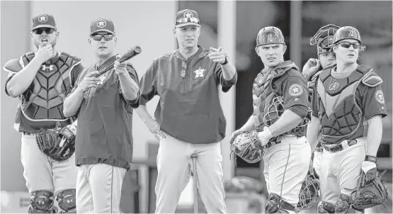  ?? Karen Warren photos / Houston Chronicle ?? Astros manager A.J. Hinch, second from the left, is working closely with the catchers as they try to develop chemistry with the pitchers during spring training.