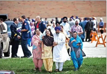  ?? The New York Times/NATHAN WEBER ?? A family member of a victim of the mass shooting at the Sikh Temple of Wisconsin receives consolatio­n during a wake and visitation service at the high school in Oak Creek, Wis., in 2012. Their pain was remembered Sunday when they received news of the...