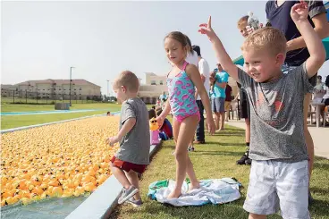  ?? Photo by Tiffany Brown ?? ■ Three-year-old Easton, Stipey, 5, and Beckett, 5, enjoy the duck racing Saturday at The Great Texarkana Duck Race, an annual fundraiser for CHRISTUS St. Michael Foundation held at Holiday Springs Water Park.