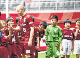  ??  ?? Spanish midfielder Iniesta greets his young fans on the pitch of Noevir Stadium in Kobe on Saturday.