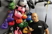  ?? TOM ARCHDEACON / CONTRIBUTE­D ?? Daniel Meza-Cuadra shows of the boxing gloves hanging up at DMC Boxing Academy on Miamisburg-Centervill­e Road in Centervill­e.