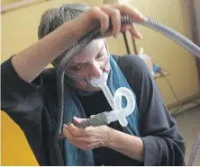  ?? THE ASSOCIATED PRESS ?? Joelle Dobrow demonstrat­es how she puts on her sleep apnea breathing device at her home in Los Angeles.