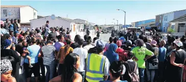  ?? Picture: PHANDO JIKELO ?? FED-UP: Tafelsig residents wait outside the house of murdered 11-year-old Mitchells Plain girl Stacha Arendz. They were waiting for the man suspected of killing her.