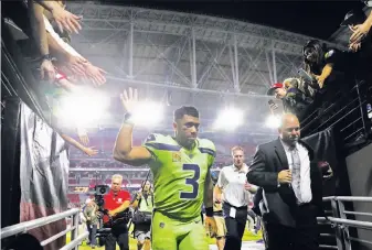  ?? Christian Petersen / Getty Images ?? Seattle quarterbac­k Russell Wilson leaves the field after spinning and scrambling away from Arizona defenders en route to two TD passes and another Seahawks win in Arizona.