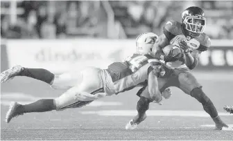  ??  ?? Alouettes defender Branden Dozier dives to tackle Stampeders running back Roy Finch during secondhalf action in Montreal on Friday.