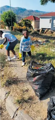  ?? ?? Two youngsters help in the clean-up efforts. > Photo: Thea Rix