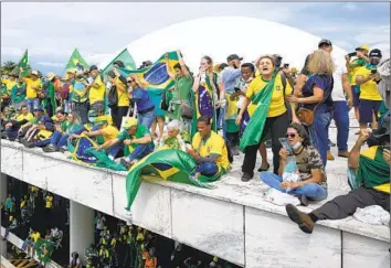  ?? Photograph­s by Eraldo Peres Associated Press ?? SUPPORTERS of Jair Bolsonaro, Brazil’s former president, crowd the roof of the National Congress building in Brasilia after storming it Jan. 8. Bolsonaro loyalists say Justice Alexandre de Moraes is muzzling expression.