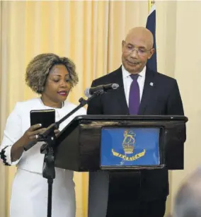  ?? ?? New minister without portfolio in the Office of the Prime Minister, Dr Dana Morris Dixon, takes the Oath of Office and Oath of Allegiance during a swearing-in ceremony held at King’s House on Thursday. Looking on is Governor General Sir Patrick Allen.