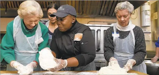  ??  ?? (From left) Michaela Walsh, Chef Sheri Jackson and Sandy Garfunkel prepare biscuits during “Orange Friday” for food awareness at the a food pantry in Harlem on Friday.