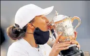  ?? Clive Brunskill / Getty Images ?? Iga Swiatek kisses the Suzanne-lenglen cup after winning the French Open on Saturday in Paris.